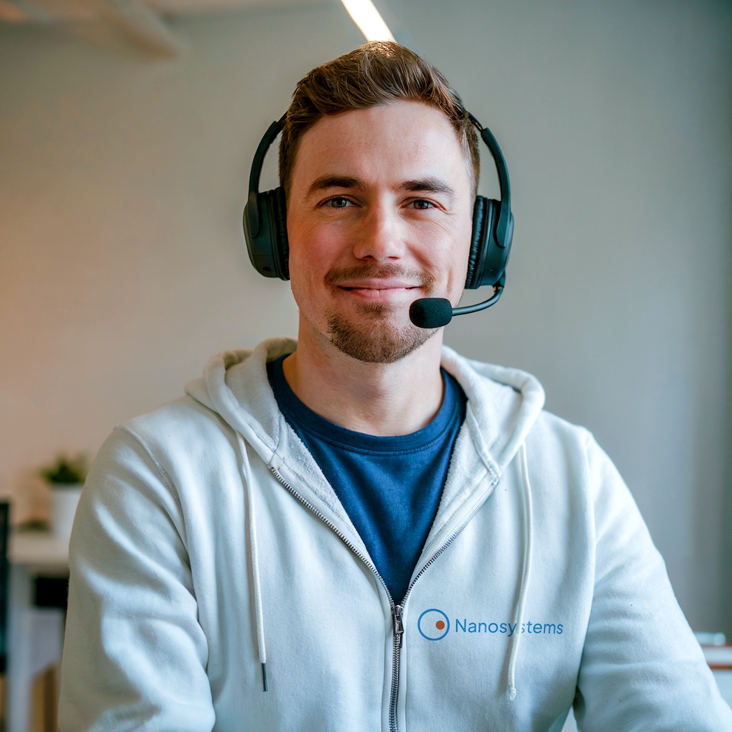 Experto en TI con auriculares, sonriendo, listo para ayudar a los socios en la distribución de software de supervisión y acceso remoto.