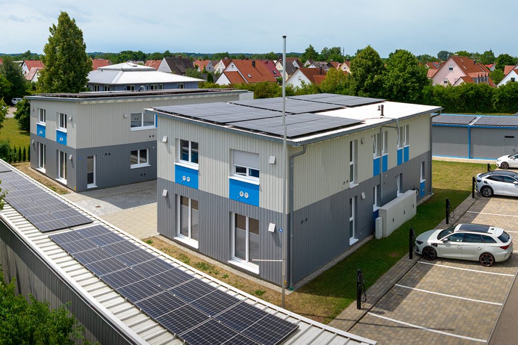 Headquarters of aconitas GmbH in Germany, modern office buildings equipped with rooftop solar panels, reflecting the company’s focus on innovation, efficiency, and sustainable IT solutions.