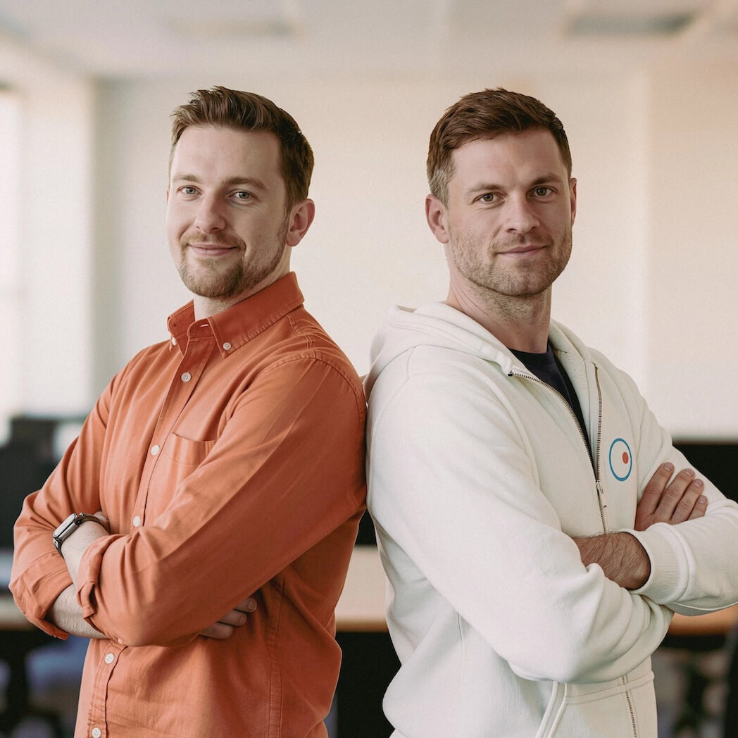 Dos sonrientes socios de TI profesionales posan juntos, representando la confianza y la colaboración para la reventa de software de control remoto.